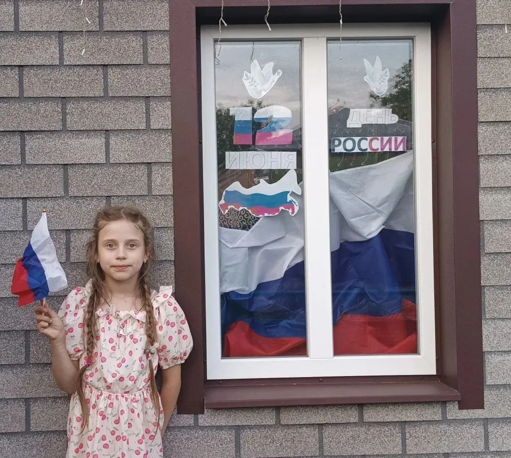 Обучающаяся 1 "А" класса Денисенко Ника принимает участие в акции "Флаги России" в преддверии торжес