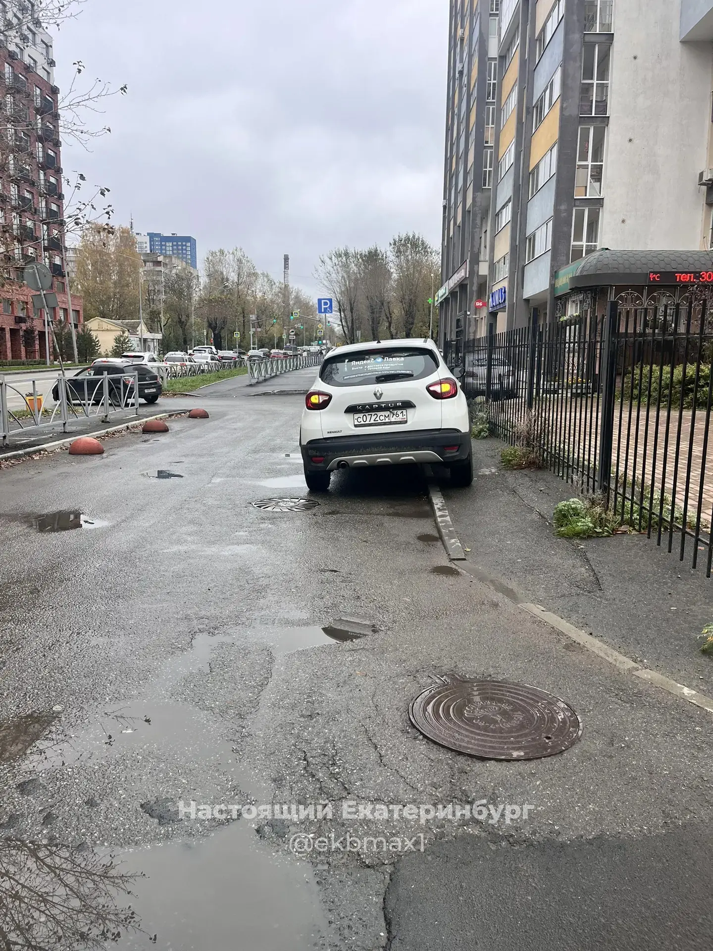 Стоит на тротуаре, на очень узком пешеходном переходе, загораживая калитку для входа во...
