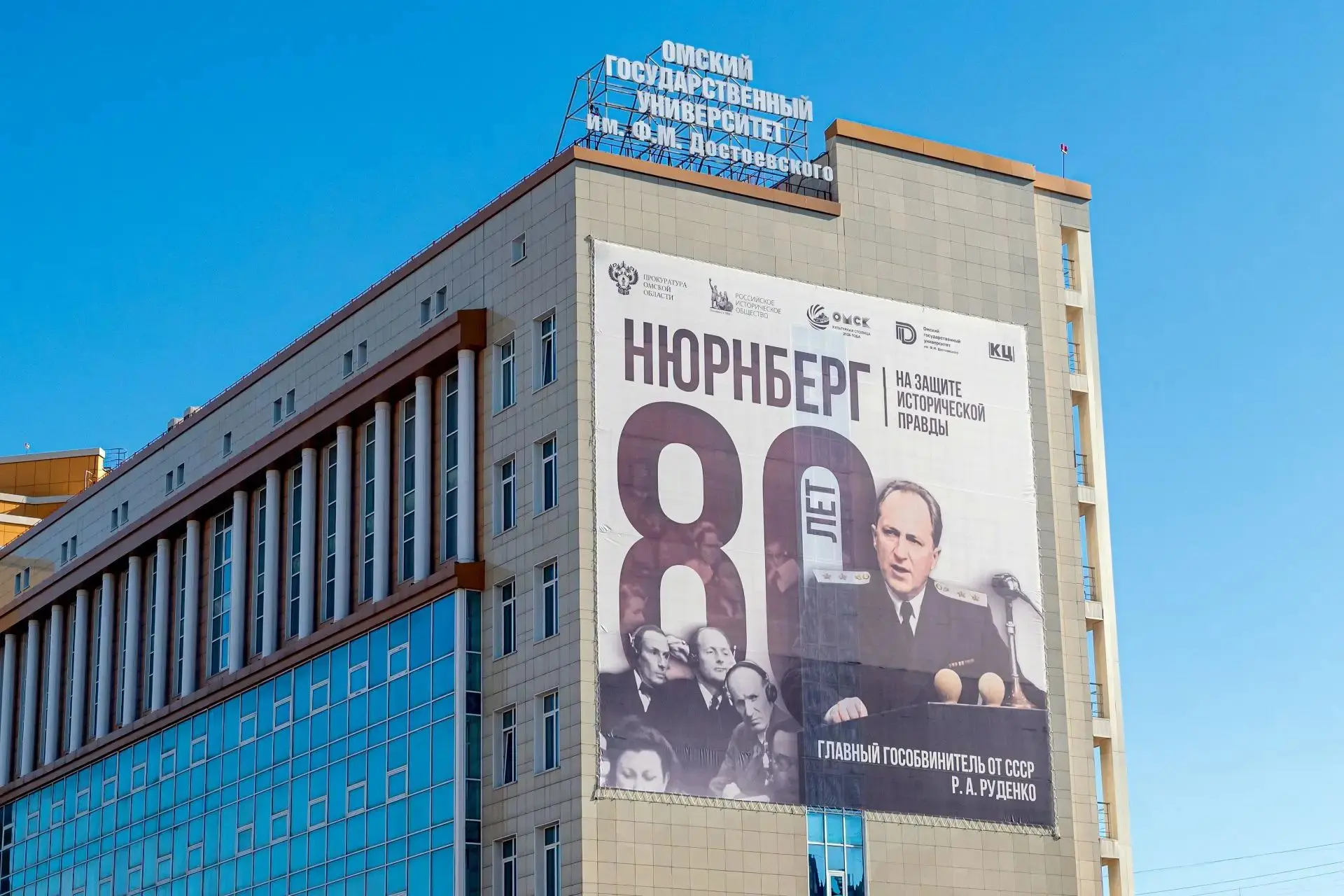 🕯️ 80 лет Нюрнбергу: на главном корпусе ОмГУ — портрет Романа Руденко