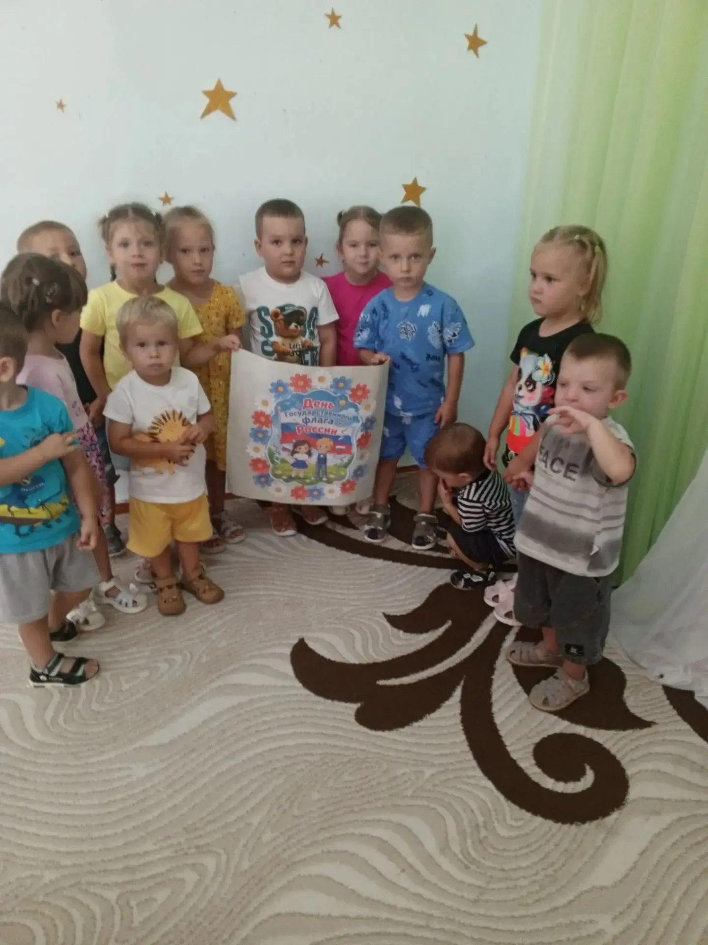 В младшей группе детского сада ребята вместе создают коллективную работу — яркий трикол...