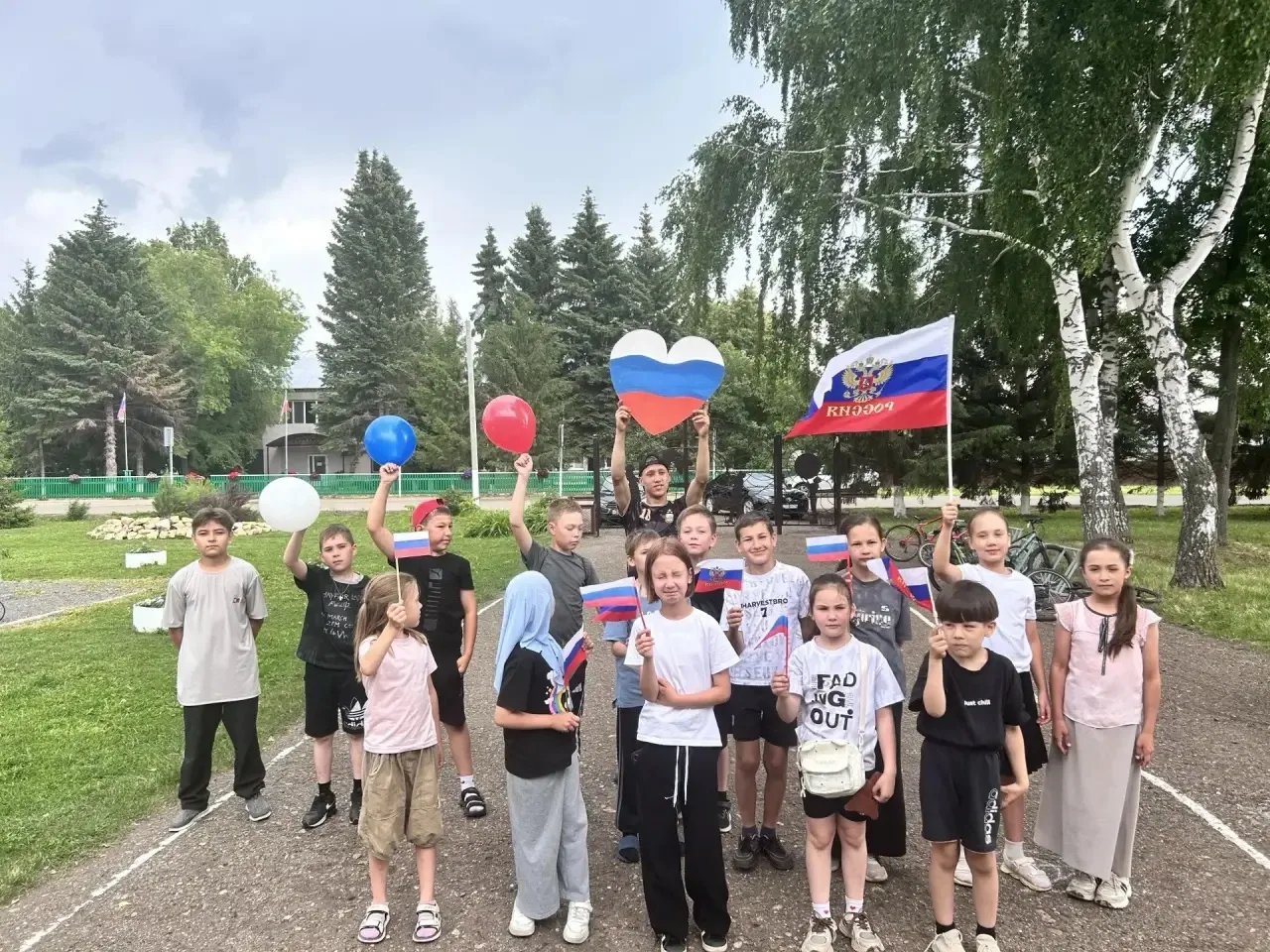 В пришкольном лагере день начался с зарядки — ребята бодро тянулись, приседали и махали руками, заря