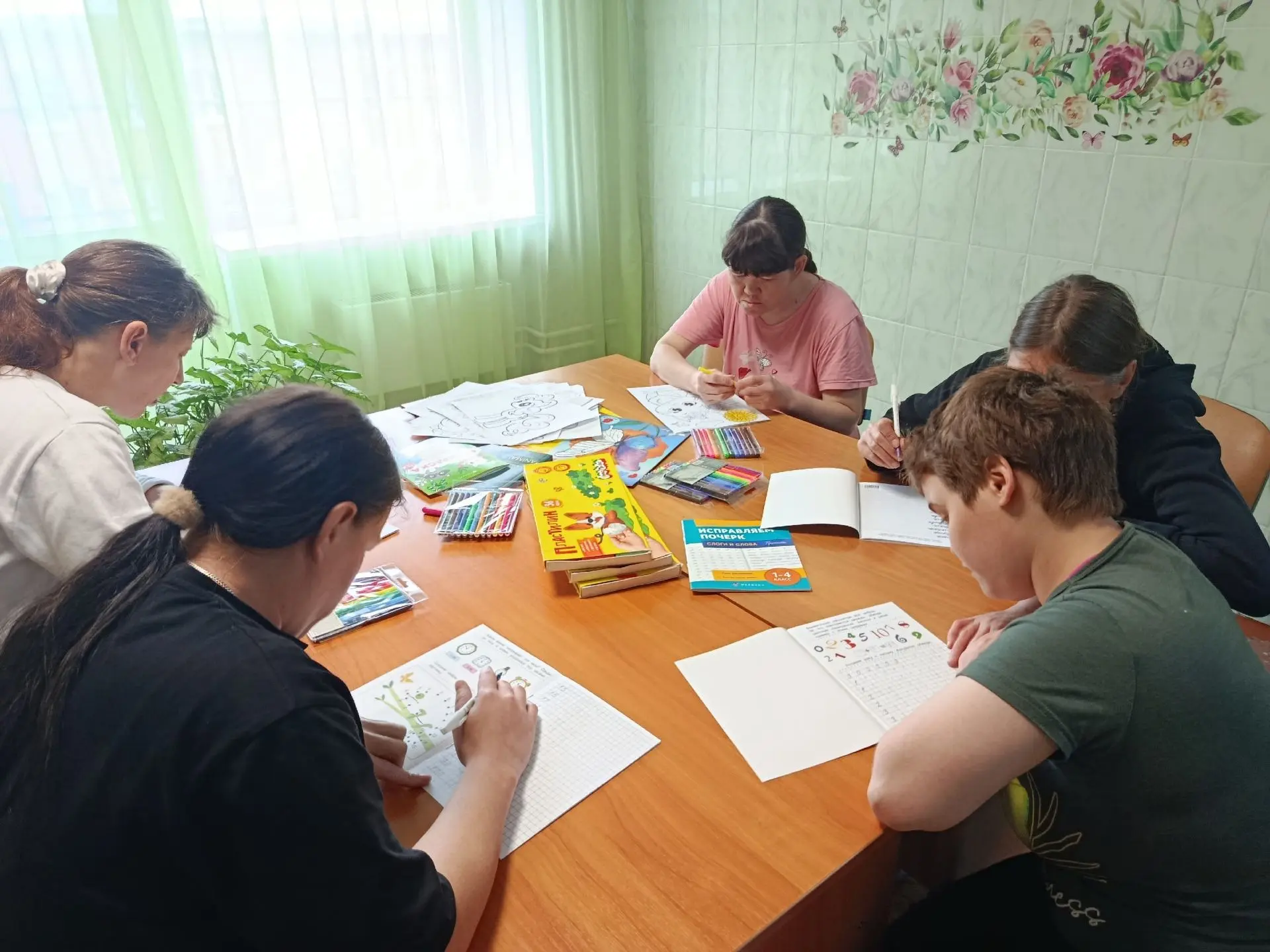 Получатели социальных услуг с увлечением погружены в дневные занятия, наполняя простран...