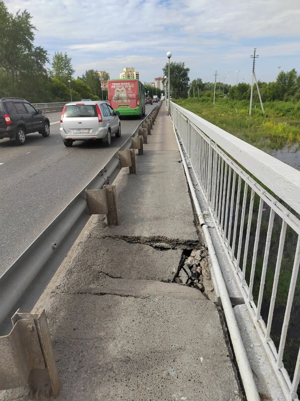 На пешеходном мосту за аква парком провалился асфальт, для пешеходов можно перешагнуть ...