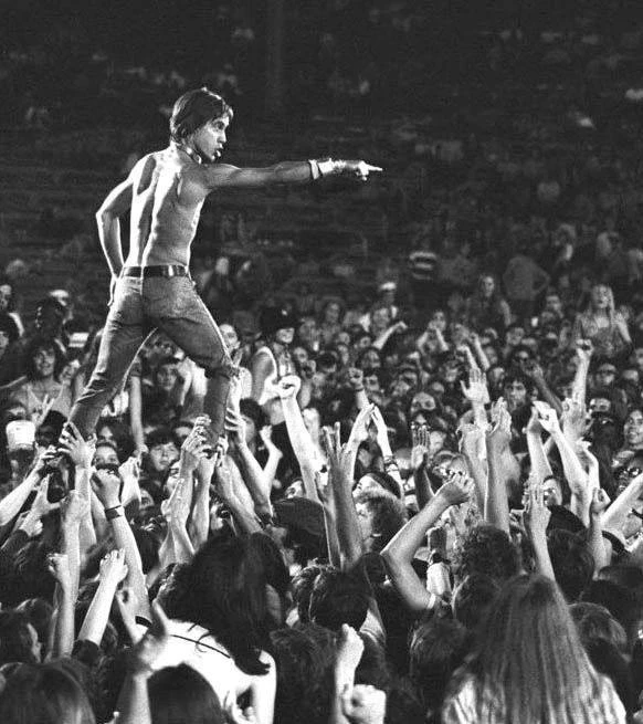 Первый 

Игги Поп (Iggy Pop)  первым из рокеров стал практиковать прыжок со сцены в толпу, позже пол