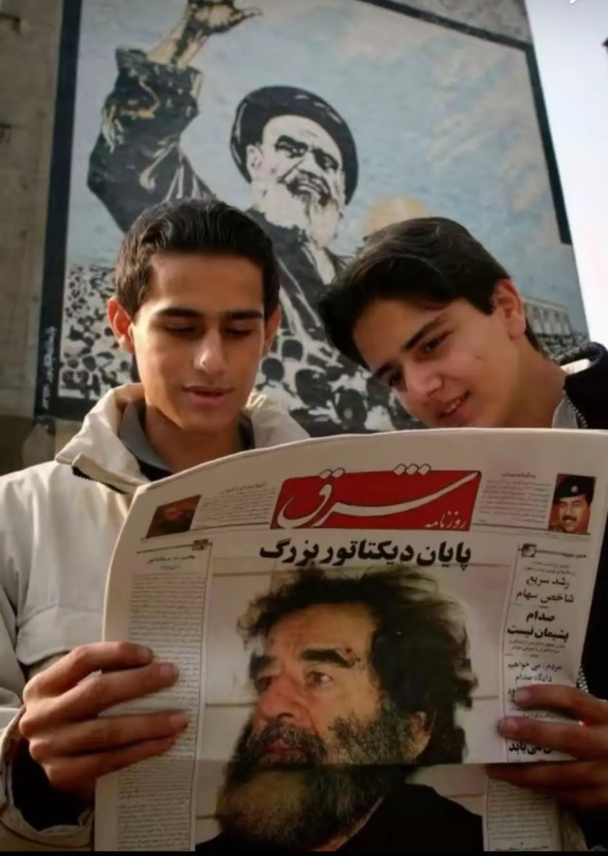 ⛓️📸🇮🇷🇮🇶 Два молодых иранца читают новости о захвате американцами Саддама Хусейна. Тегеран, дека