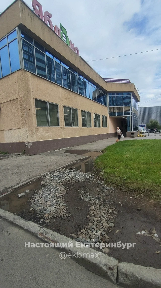 У магазина Яблоко лужа на тротуаре, который с этой ямой уже много лет. И рядом испорчен...