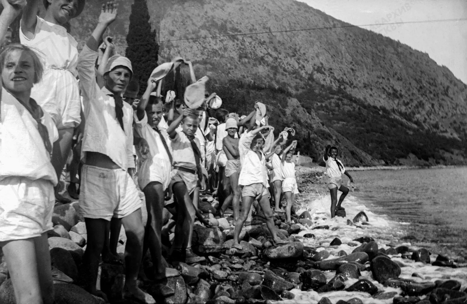 Отдыхающие пионерского лагеря «Артек» в 1929 году наслаждаются экскурсиями на побережье...