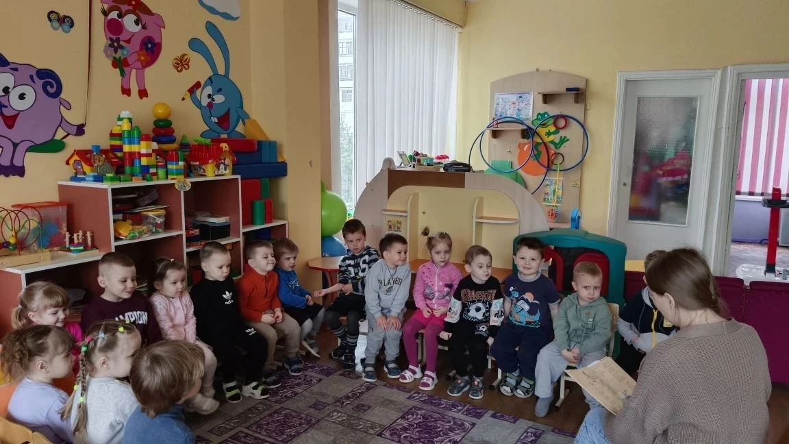 Воспитатель с увлечением читает детям стихотворение Агнии Барто «Девочка чумазая», дети...