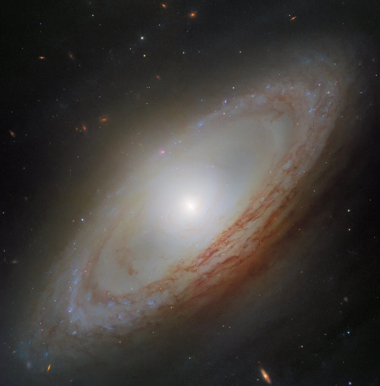 Спиральная галактика NGC 4698 на этом снимке «Хаббла» выглядит безмятежно, но скрывает ...