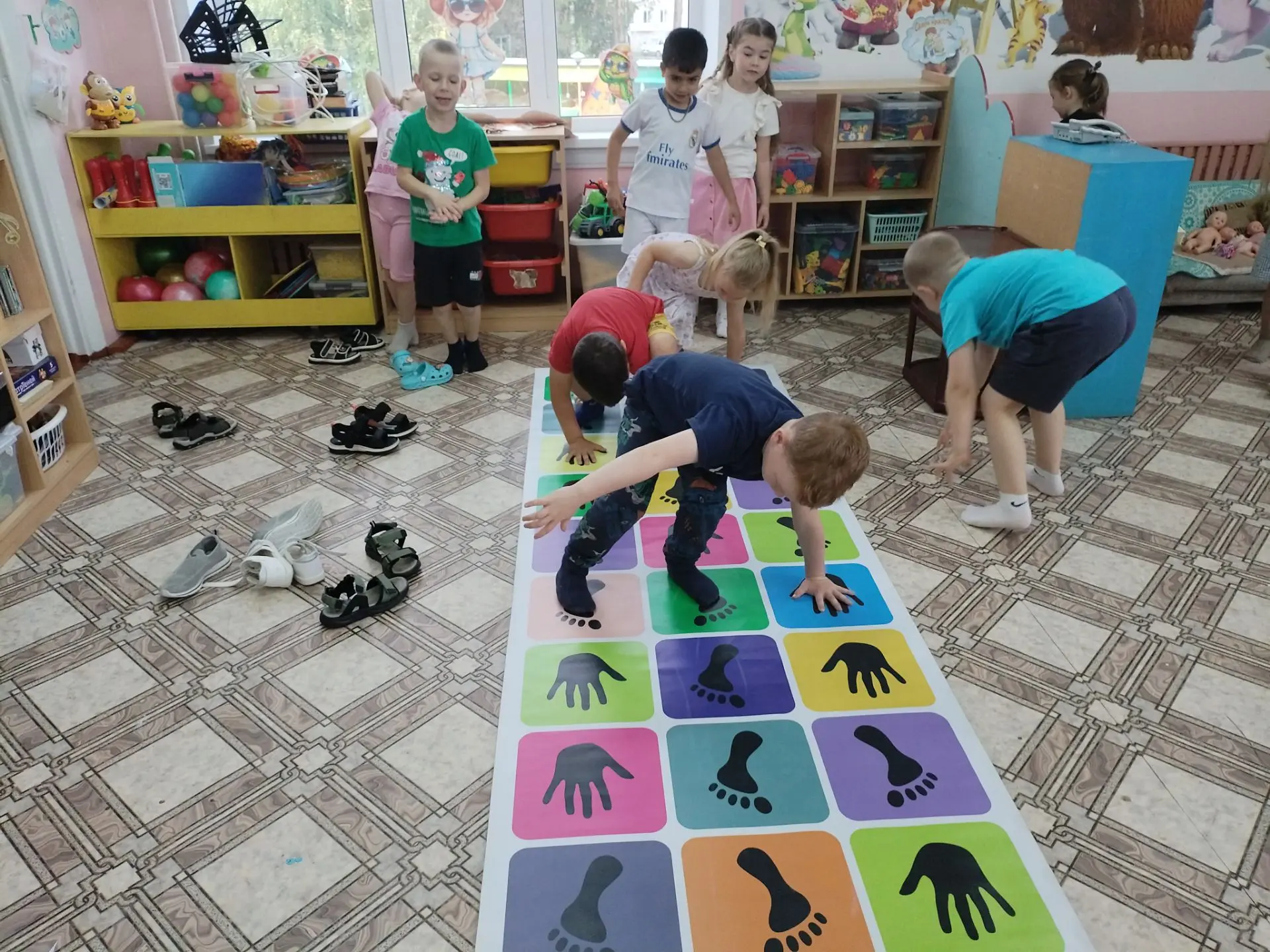 Ребята вовсю веселились: играли в «Руки и ноги» — тренировали ловкость и учились поддер...