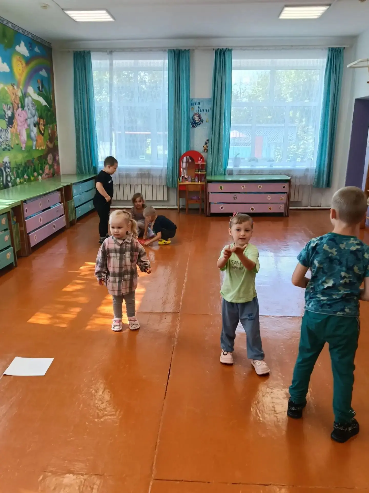 В детских ручках — маленький флажок.