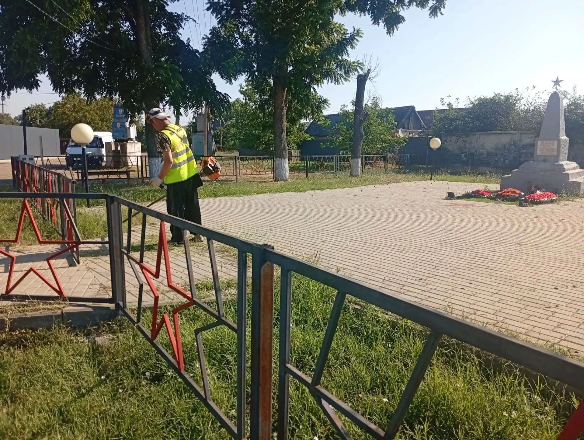 Работники МАУ "Сервис" осуществляют работу по покосу сорной травы на мемориале "Братская могила" , т