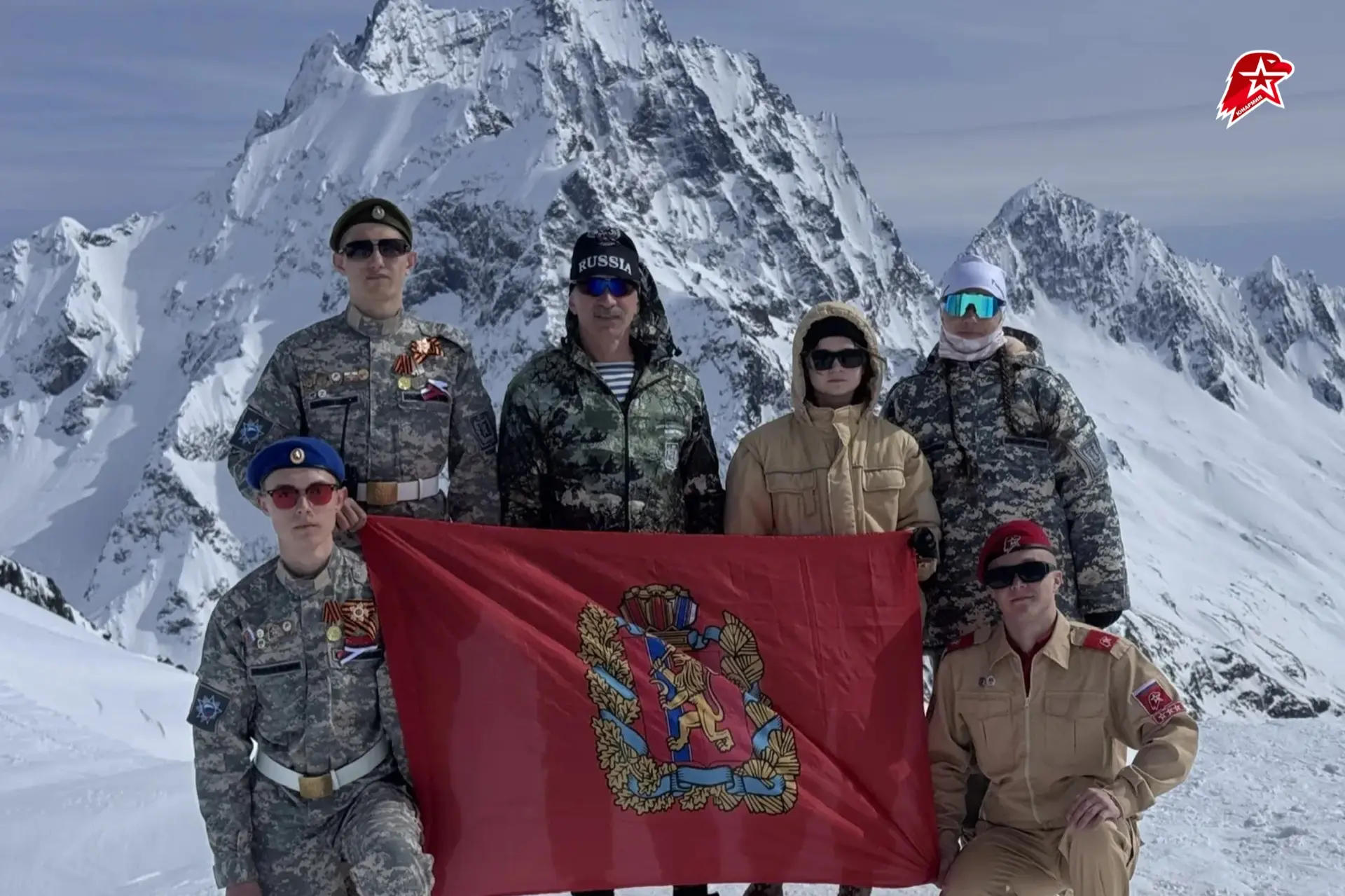 С высоты Домбая — с флагом родного края 🗻  Ребята из Красноярского края поднялись в горы и развернул