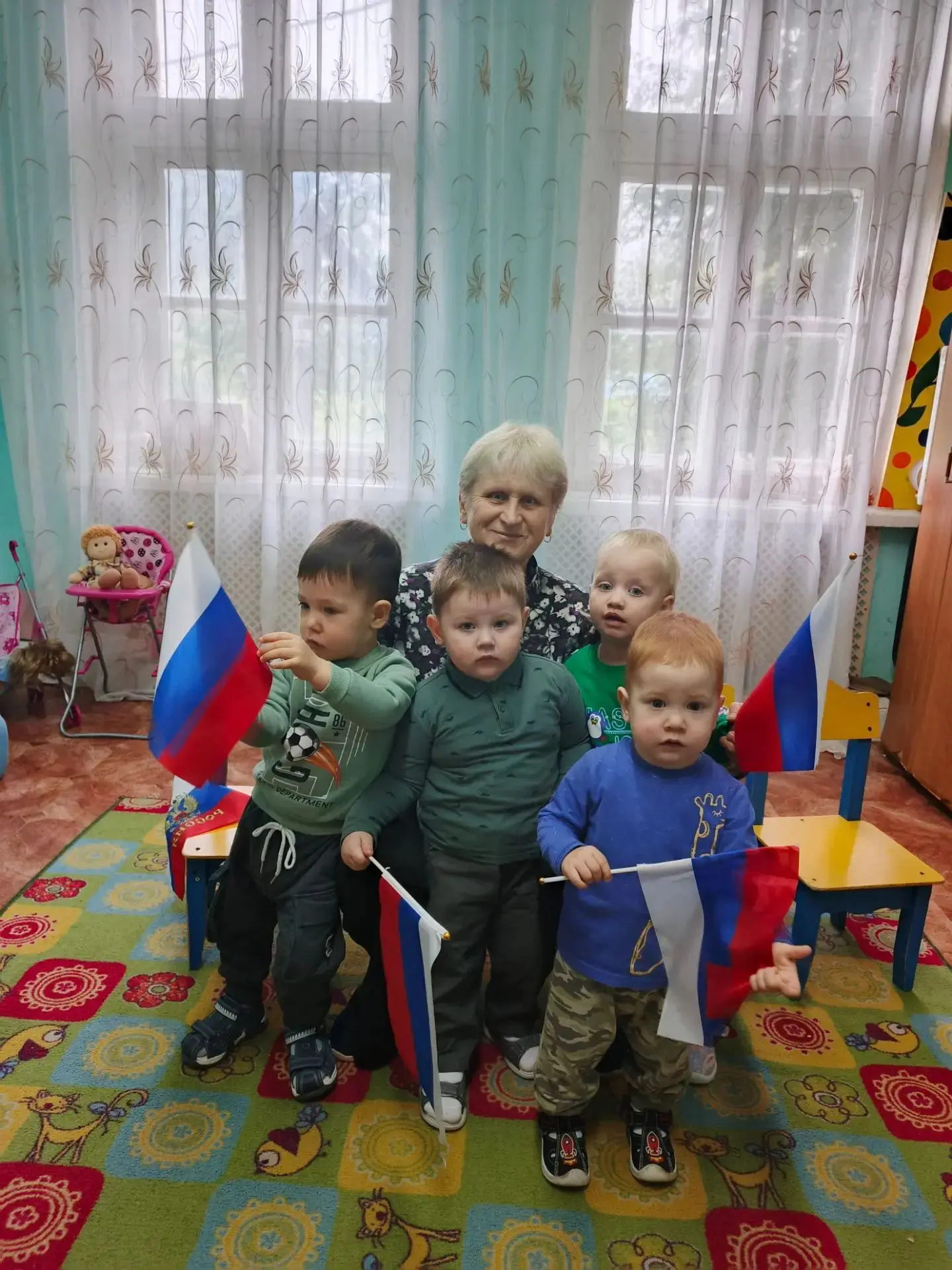 На первой младшей группе А малыши слушали песенки про флаг.
