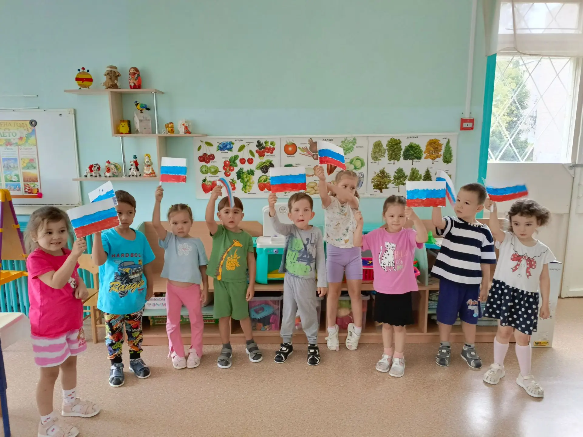 В детских ручках- маленький флажок.