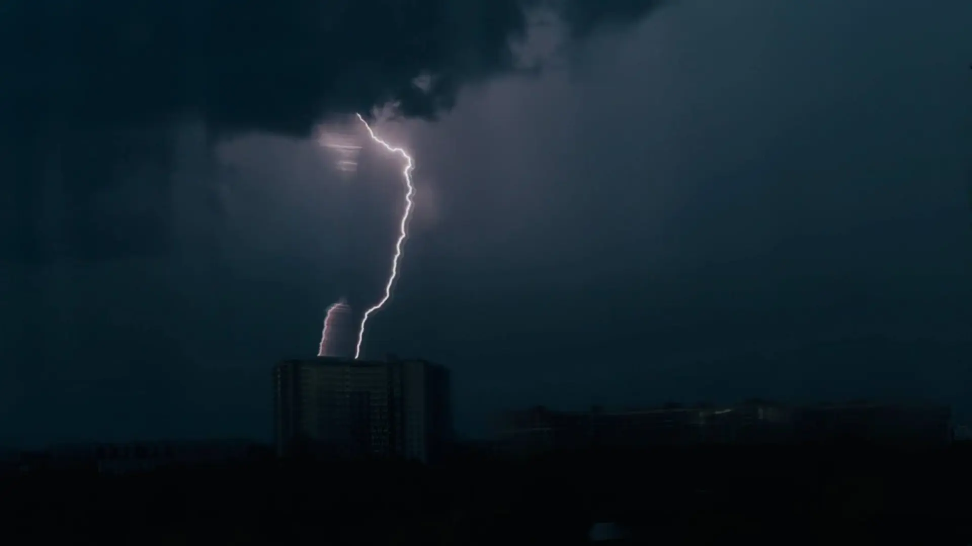 Мощные молнии в небе над городом.