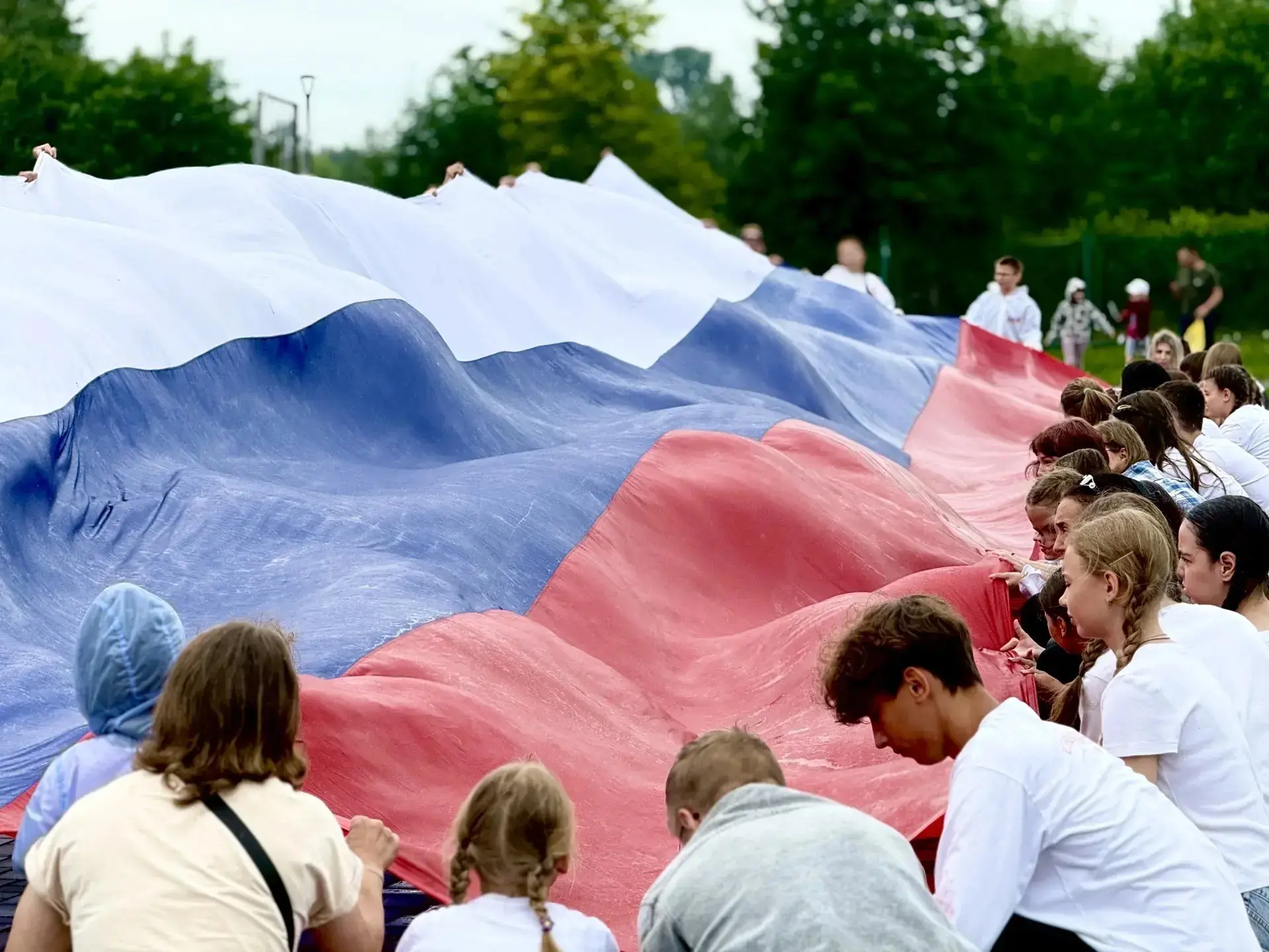 Для спортсменов участие в выносе 20-метрового флага в День России — это значимый ритуал. 
Он символи