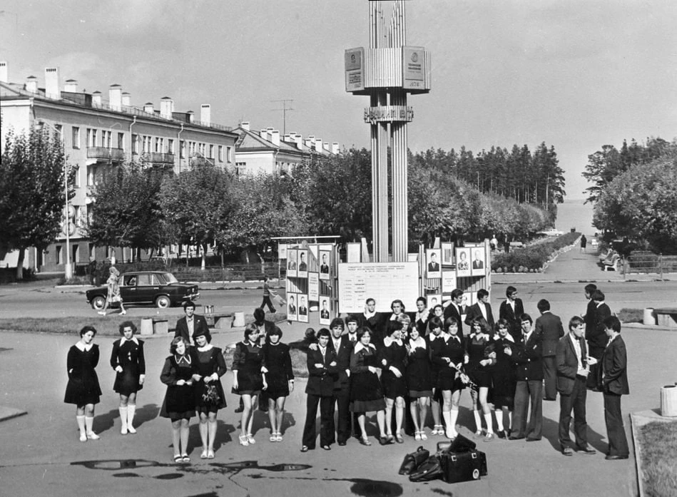 Мини и клёши. Выпускники и выпускницы на фоне инсталляции с передовиками производства и ударниками к