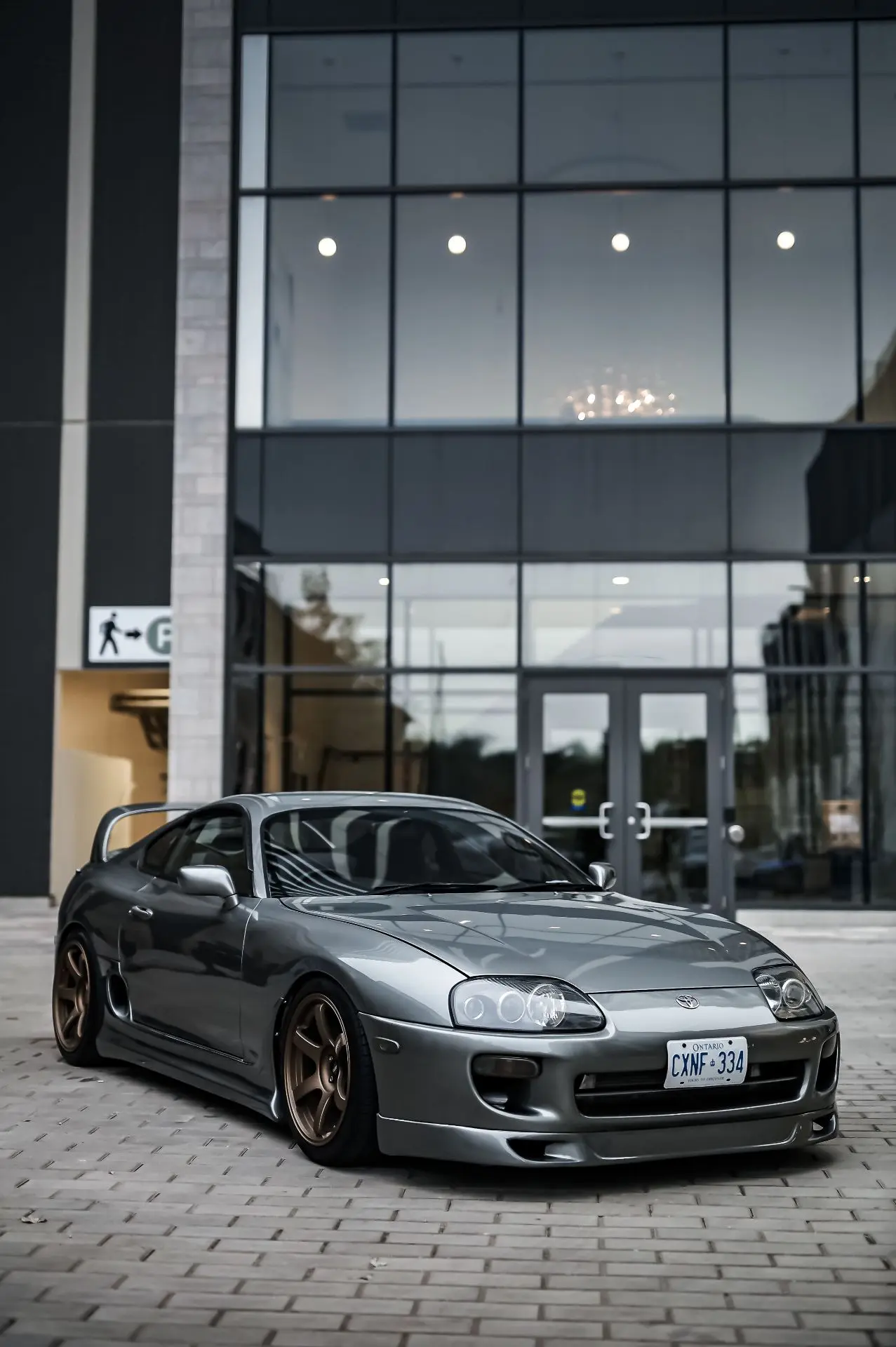 Серебристая Toyota Supra Mk4 в спокойной городской среде: длинный капот, высокая дуга к...