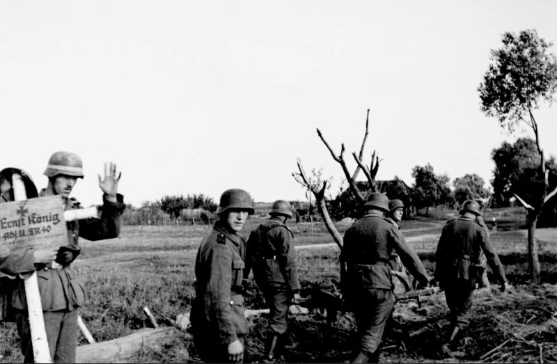 Солдаты 40-го охранного полка (Schützen-Regiment 40) вермахта хоронят погибшего сослужи...
