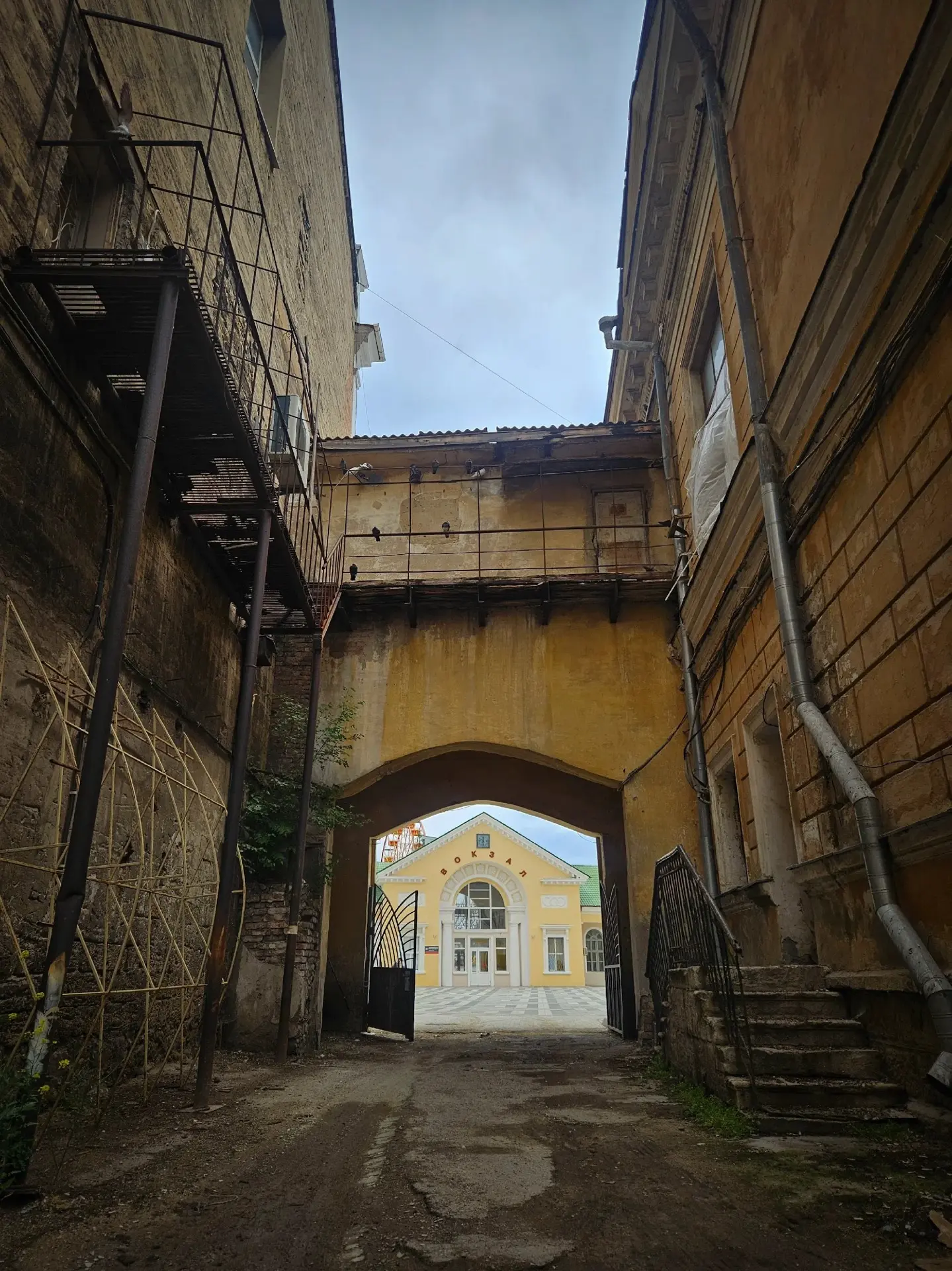 Во двор-колодец подводит длинная проездная арка - портал в былую Феодосию. На обширное замкнутое про