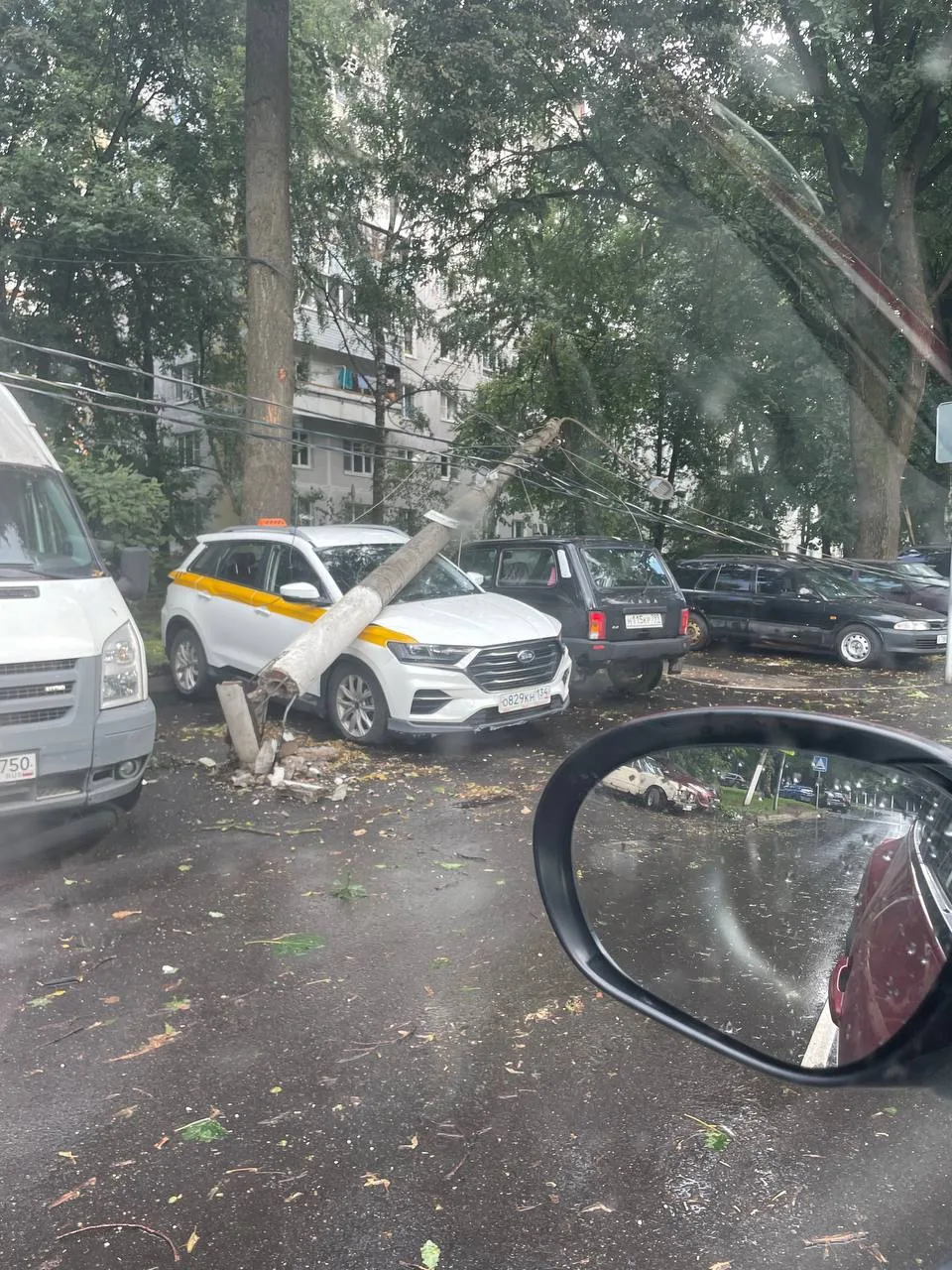 На парадном проезде во время непогоды повалило столб на машины