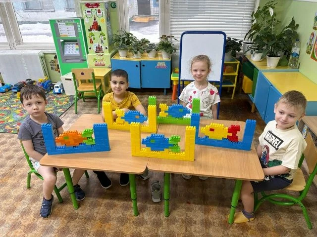 В большом аквариуме из LEGO плавают яркие рыбки. Они сделаны из разноцветных деталей ко...