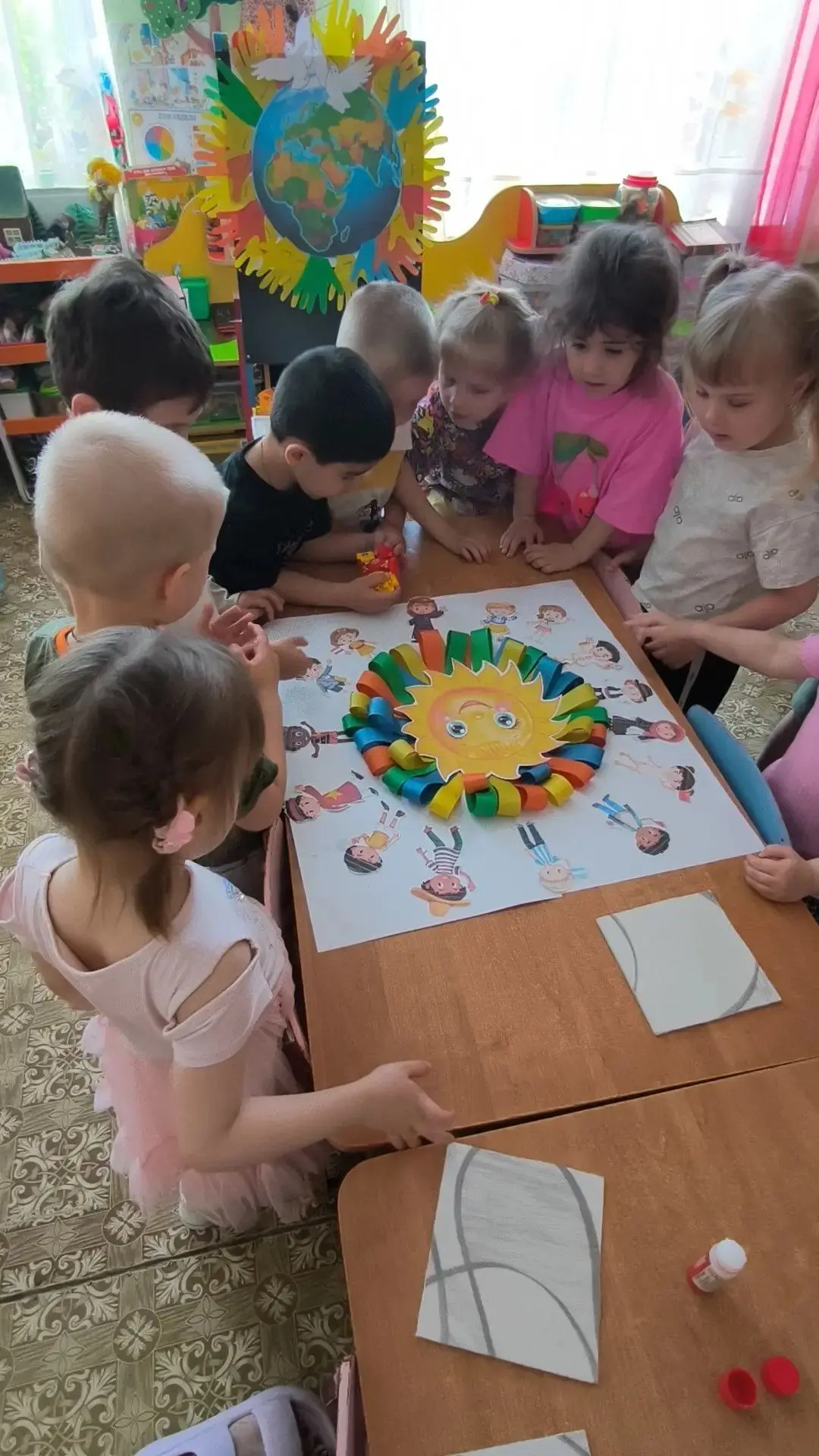 Дети из ладошек солнышко сложили,