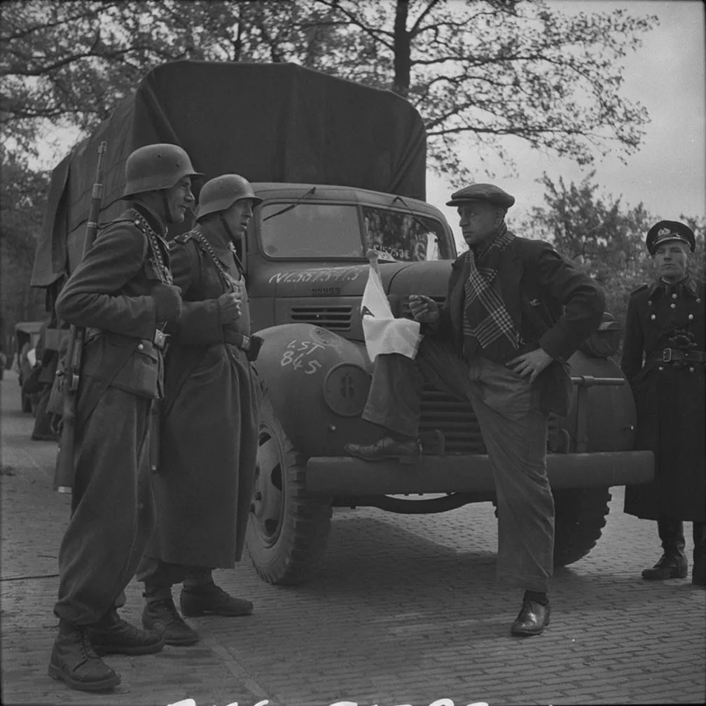 1945. Военнослужащие полевой жандармерии СС беседуют голландцем-водителем грузовика «Додж»