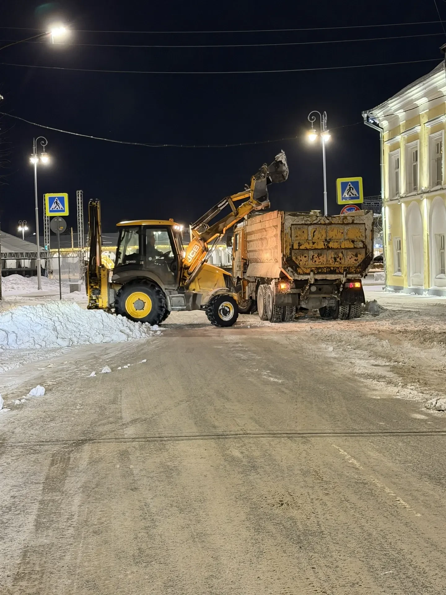 Уборка снега в ночной период на улицах города.