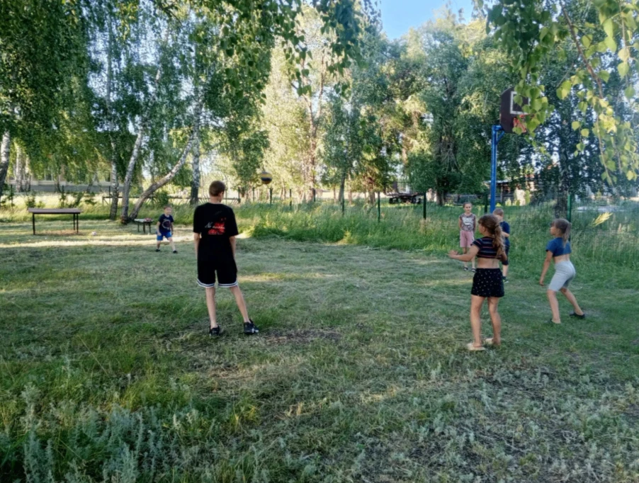 На спортплощадке кипит веселье: дети играют в вышибалы, футбол, эстафеты, крутят обручи, прыгают со 
