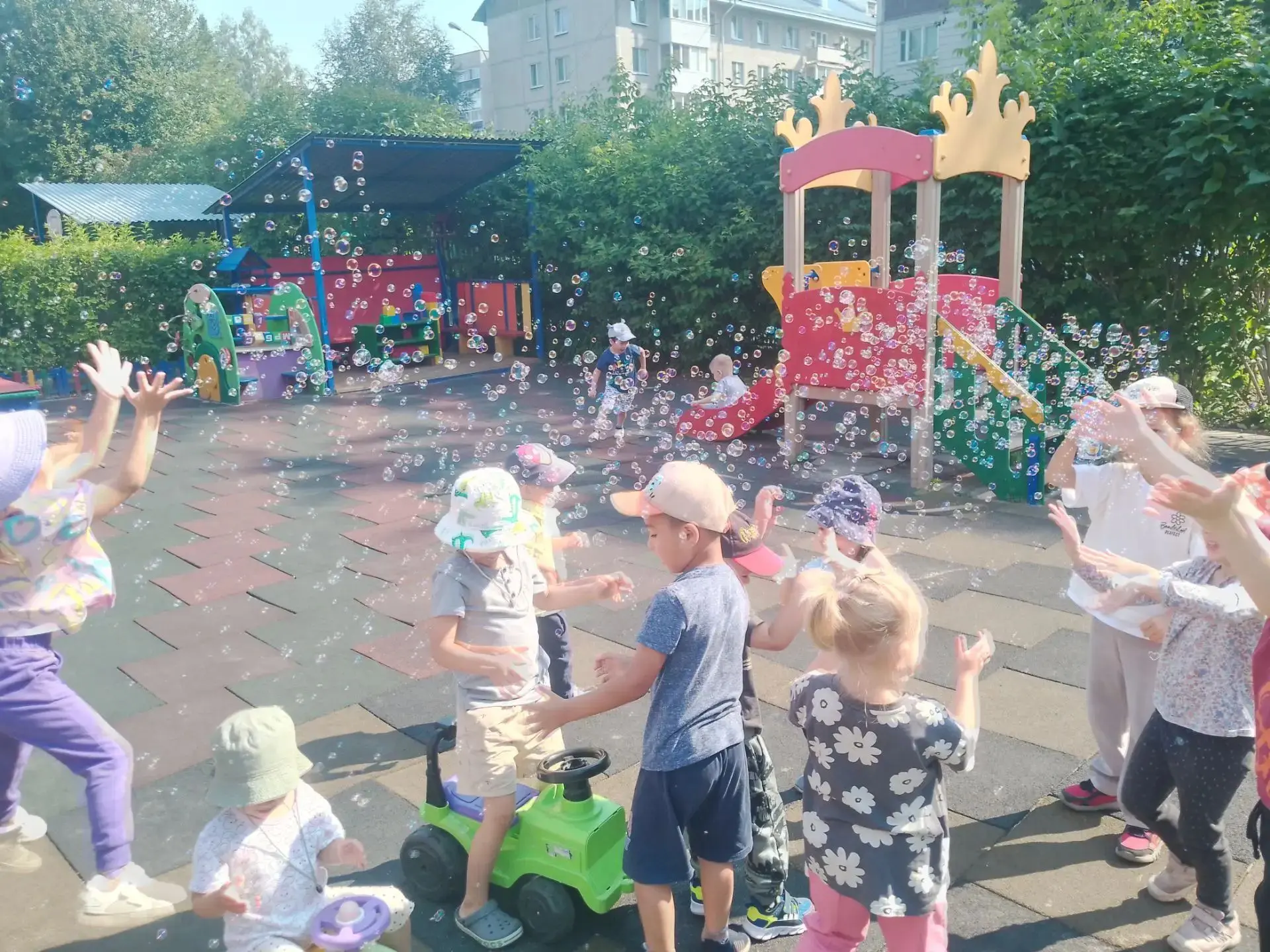 На площадке смех и визг,
Солнце льётся сверху вниз!
Вылетают пузыри —
Радугой горят шары,
Ловим их д