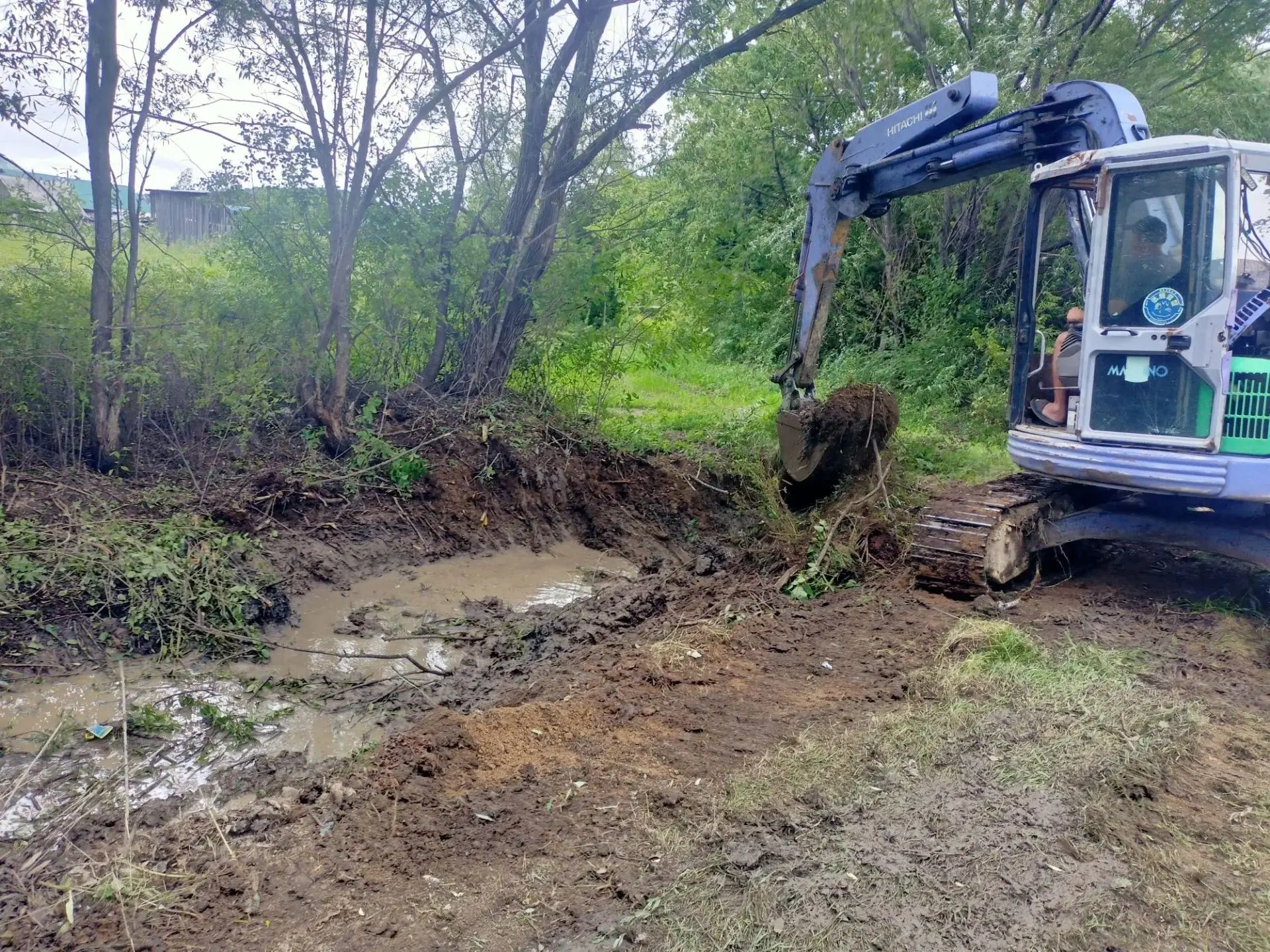🚜 В селе Анучино на улице Петровского проводится очистка водоотводного кювета.