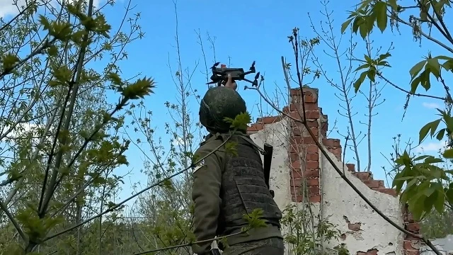 Среди руин и зарослей позицию занимает оператор дрона «Дельфин». Помощник оператора с п...
