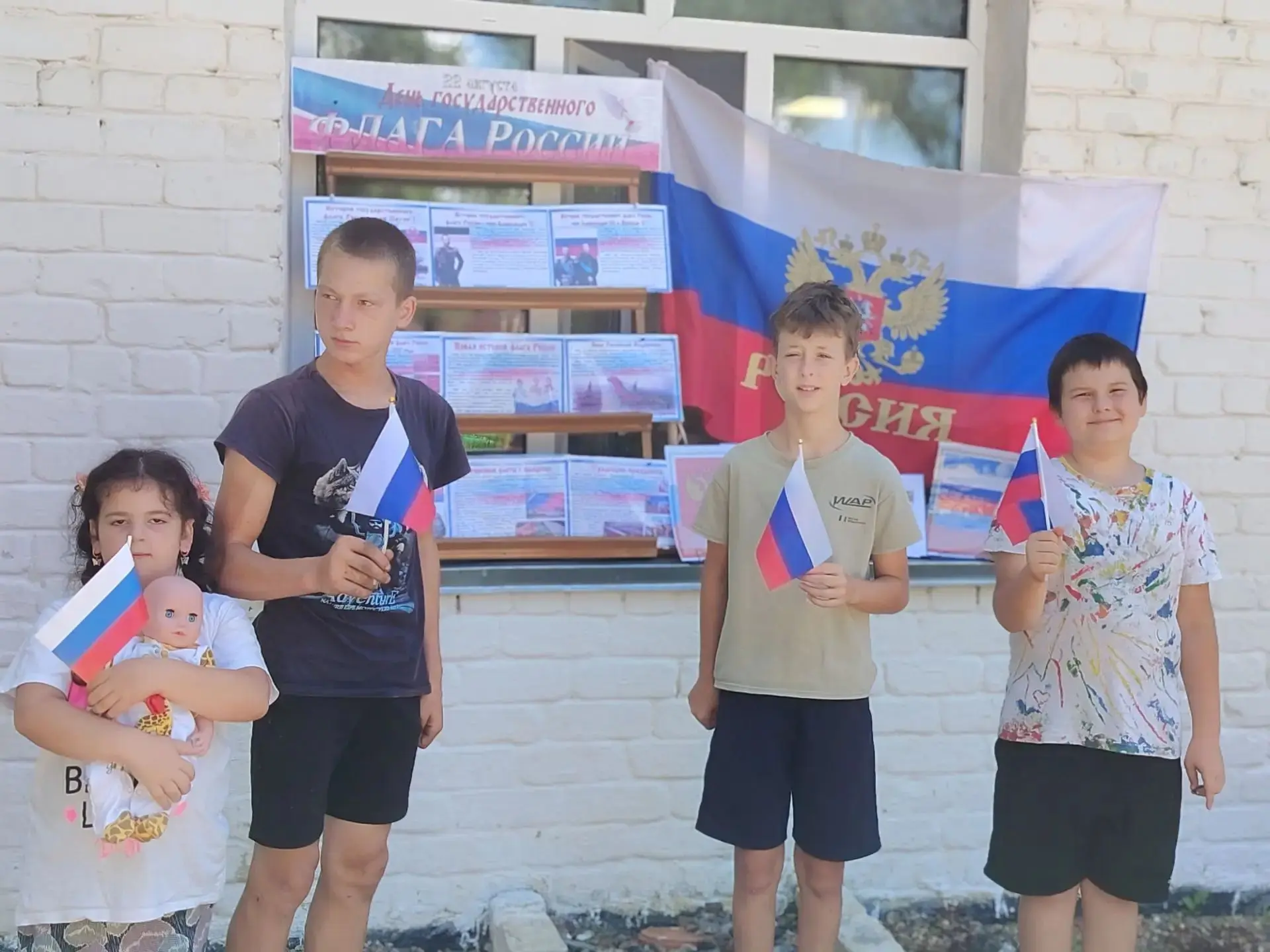 В селе Бойкое библиотекарь организовала на улице выставку ко Дню флага России. Прохожие...
