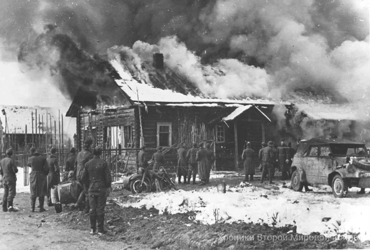 Ноябрь 1941 года, район Волхова. Солдаты вермахта наблюдают за пожаром в деревне к вост...