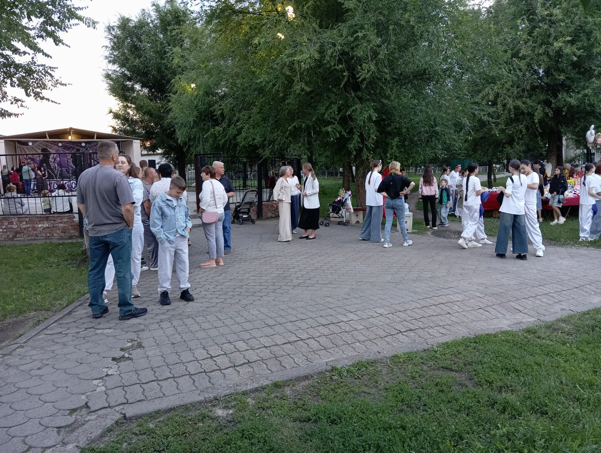 У летней площадки в нашем городе собираются на праздничный вечер. Начало через считаннв...