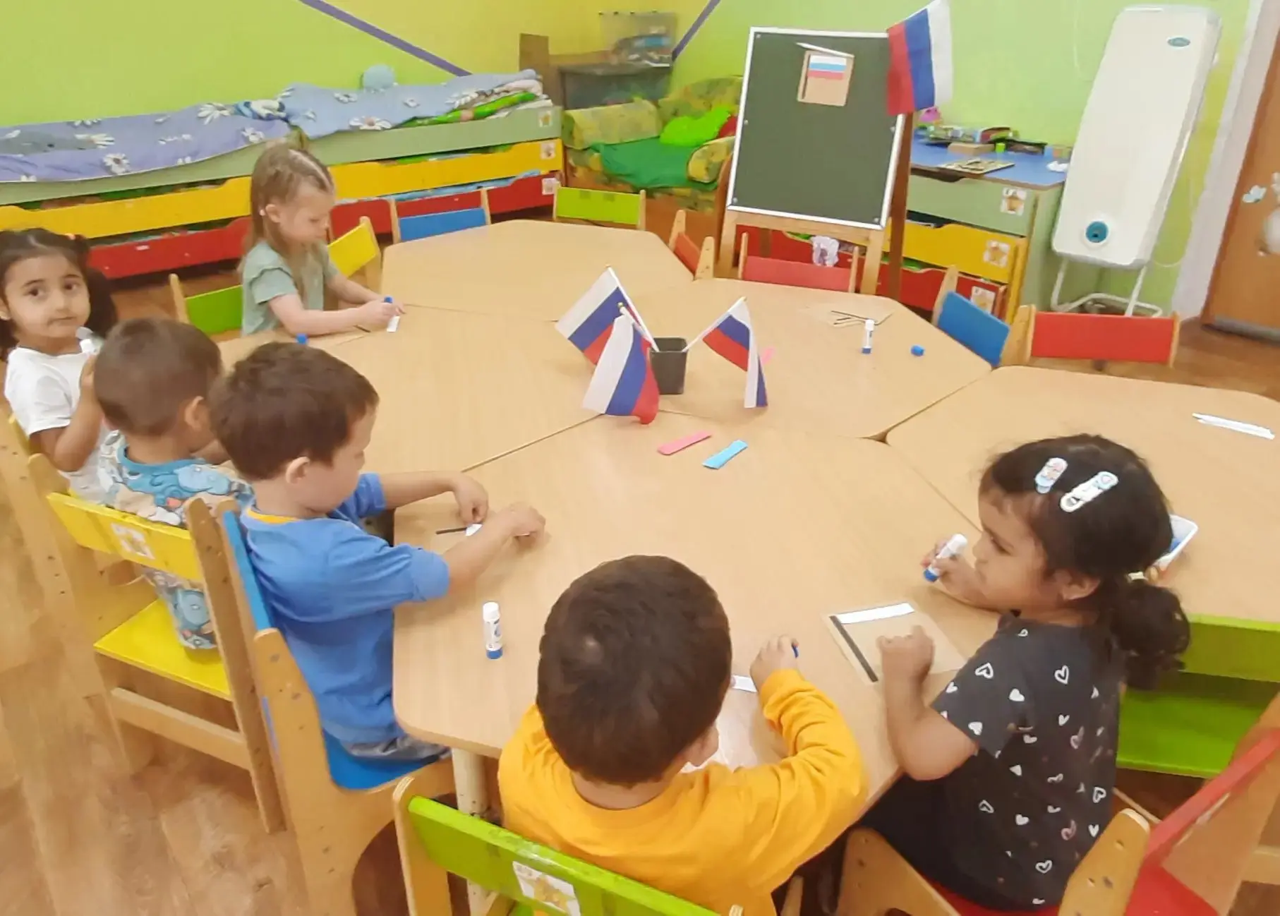 Творческое занятие в младшей группе "Звёздочки": аппликация "Флаг России" направлено на...