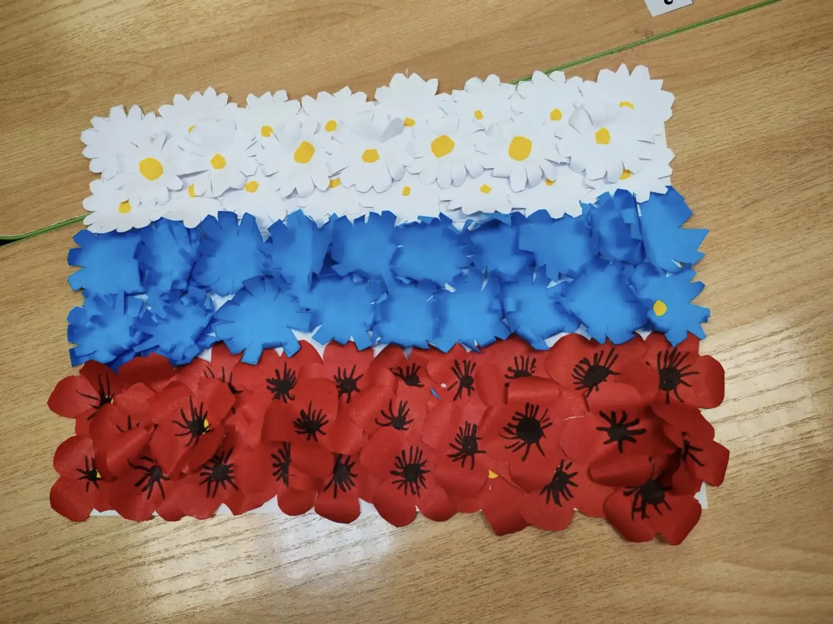 Ребята из 1 и 2 групп изобразили Российский Флаг с помощью вырезанных из бумаги цветов