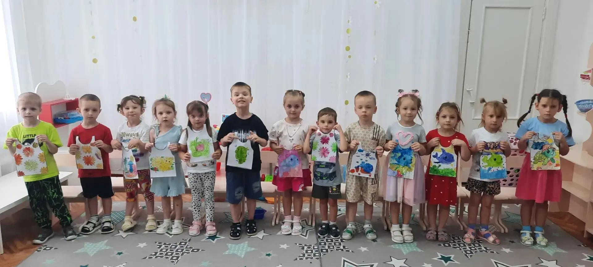Летние майки группы «Звездочки»
Мы — ребята из детсада,
Дружно взяли в руки краски!
Красим яркие руб