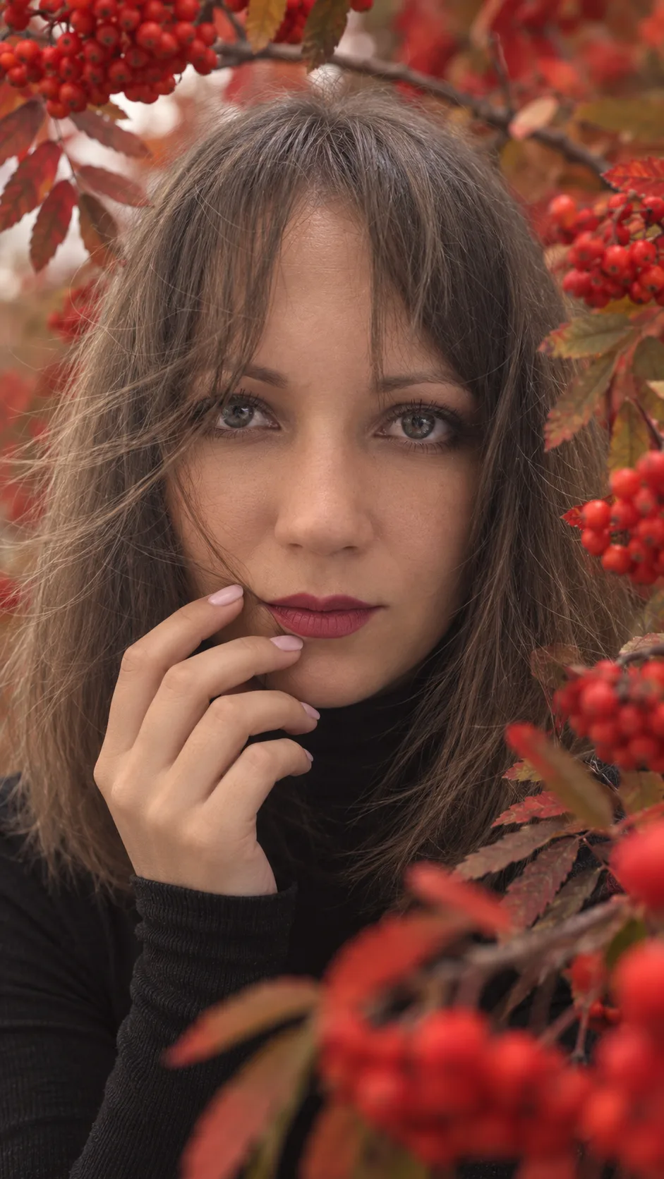 Очень крупный фотореалистичный beauty-портрет молодой женщины среди веток с ярко-красно...