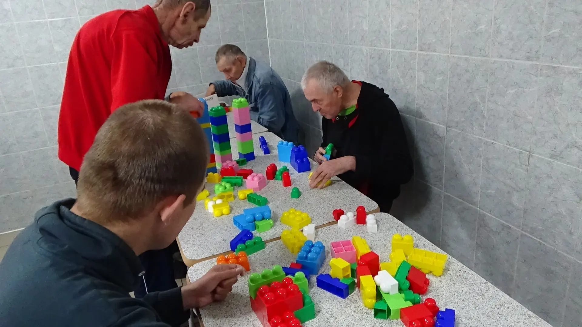 На занятиях по конструированию получатели социальных услуг работают с конструктором. Ко...