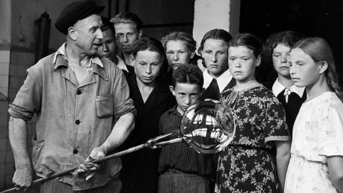 1950-е. Урок прямо у печи: стеклодув показывает школьникам, как из раскаленной массы ро...