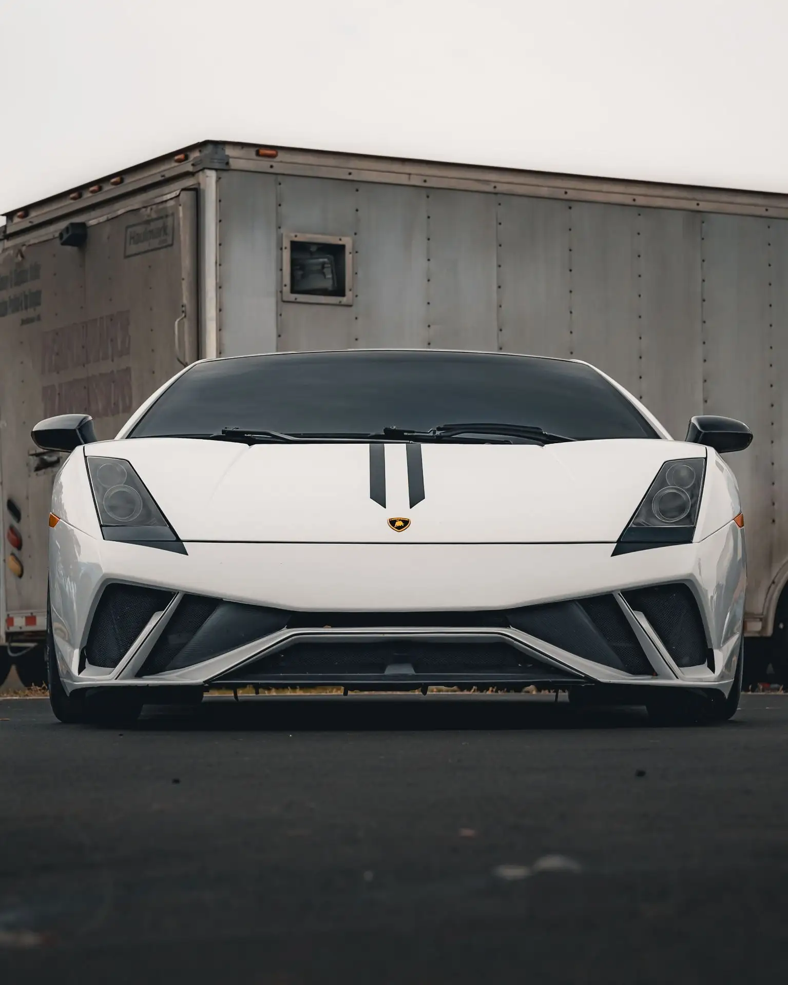Белый Lamborghini Gallardo в кадре работает почти графично: резкий клиновидный силуэт, ...