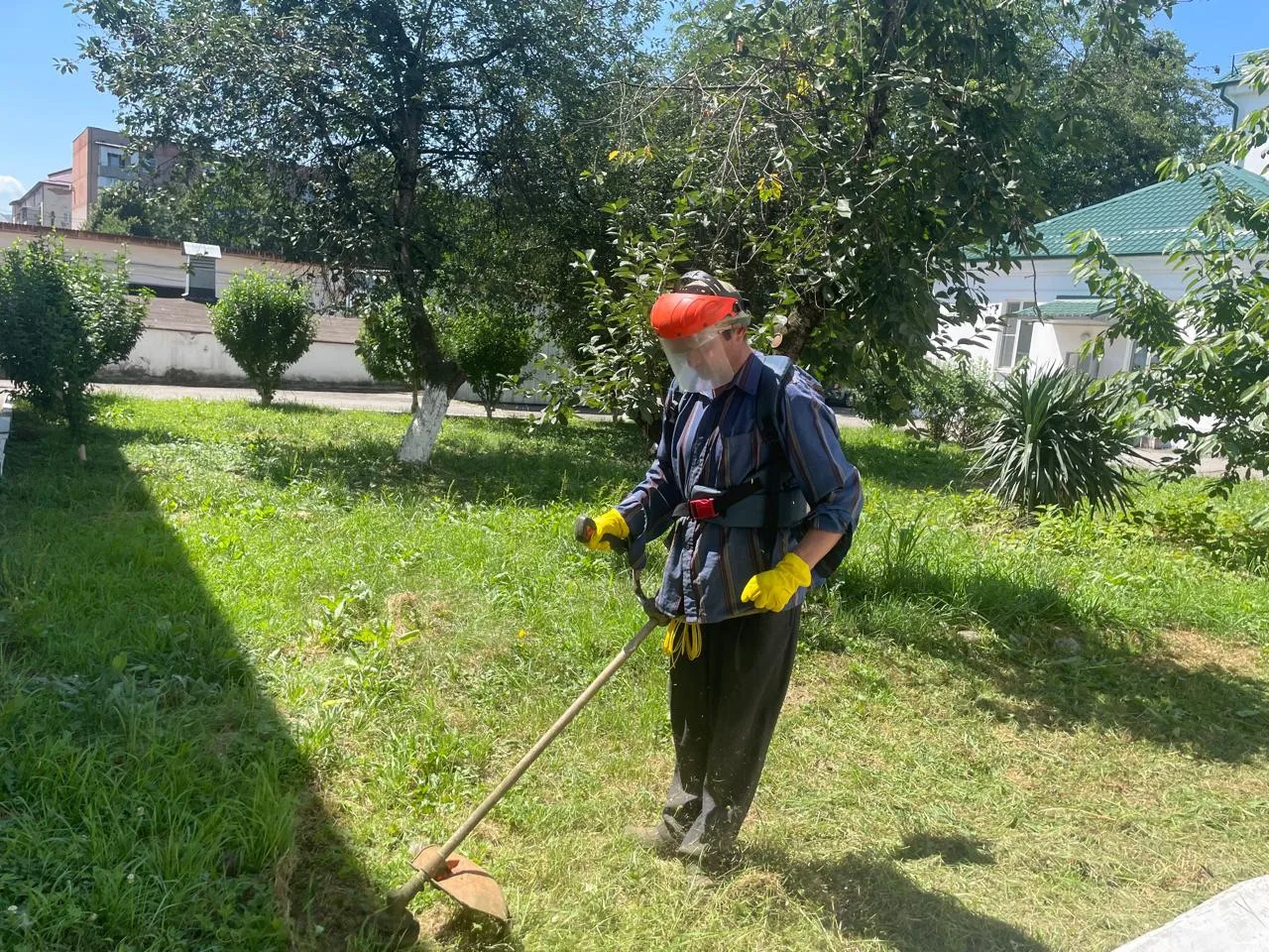 Трудотерапия в действии: на фото — один из жильцов дома‑интерната участвует в благоустройстве террит