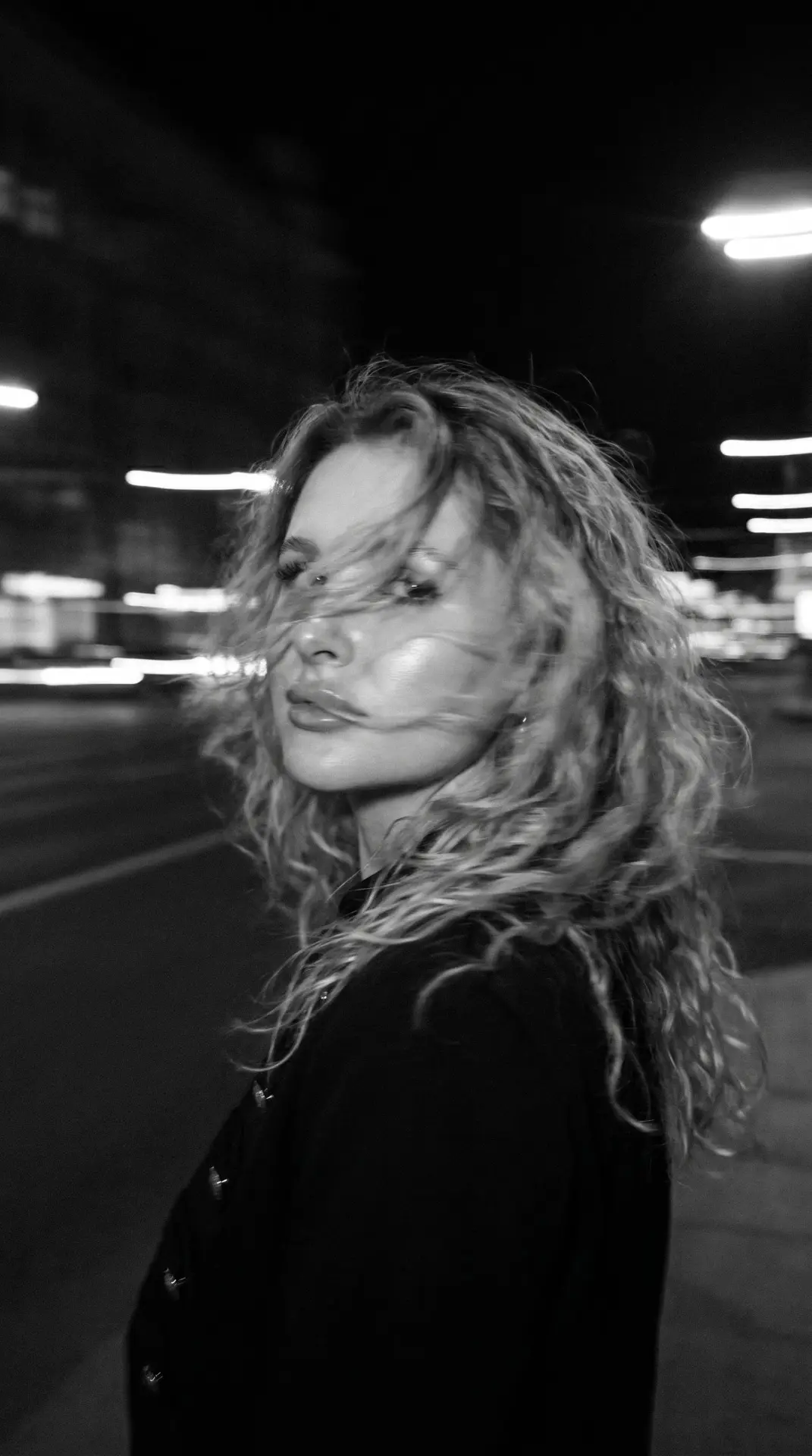 A hyper-realistic, cinematic black-and-white portrait of a woman caught in mid-motion, her face part