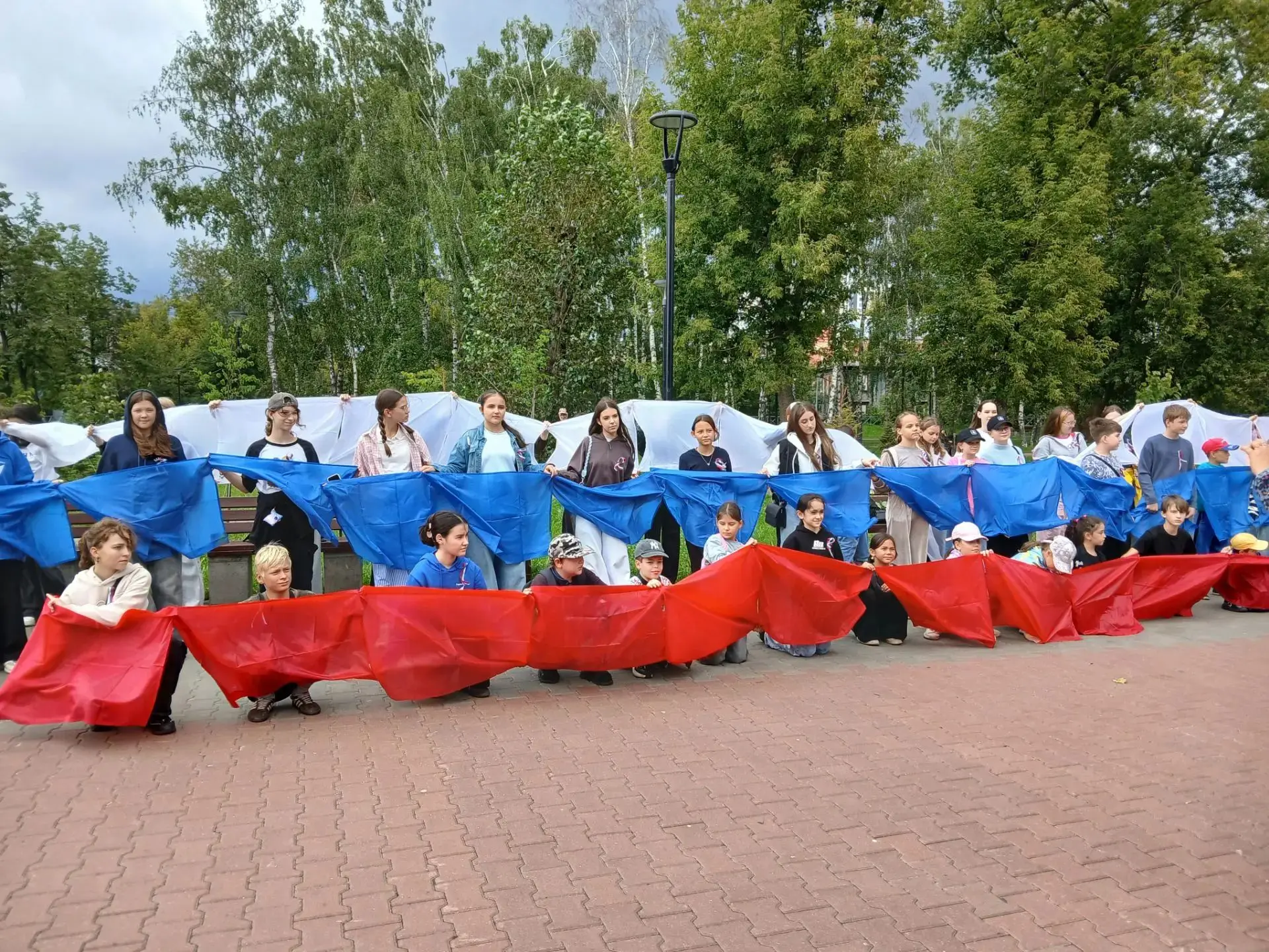 В преддверии Дня Государственного флага ребята школы и воспитанники летнего лагеря прин...