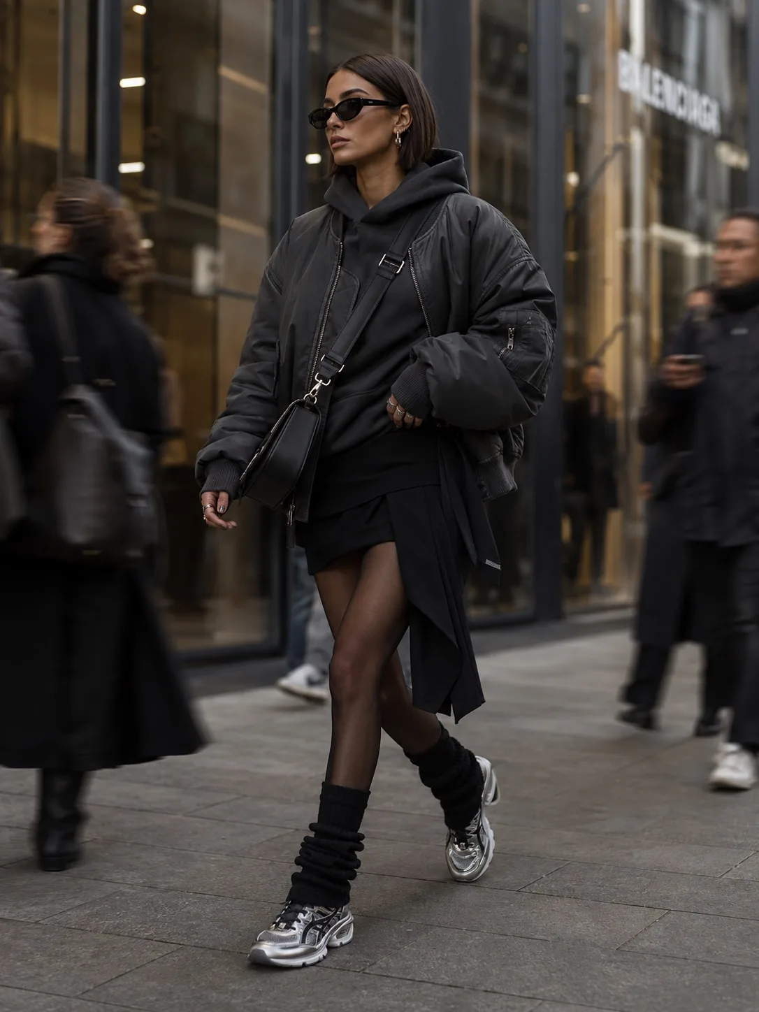 high-fashion editorial street style scene in a modern luxury shopping district, oversized charcoal b