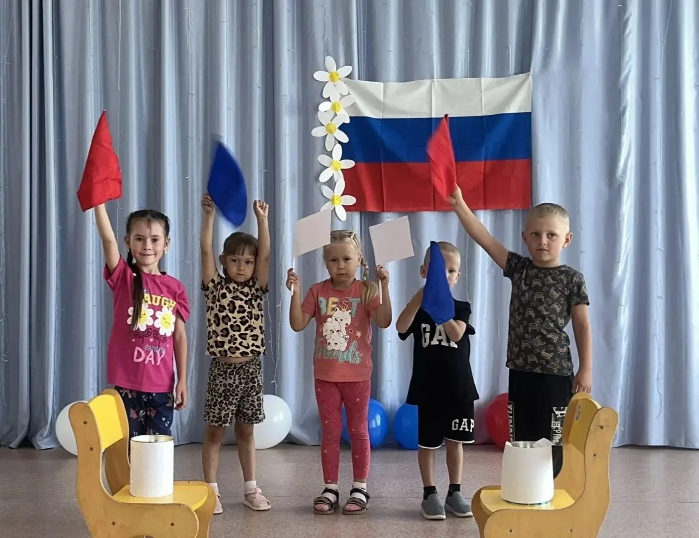В детских ручках– маленький флажок.