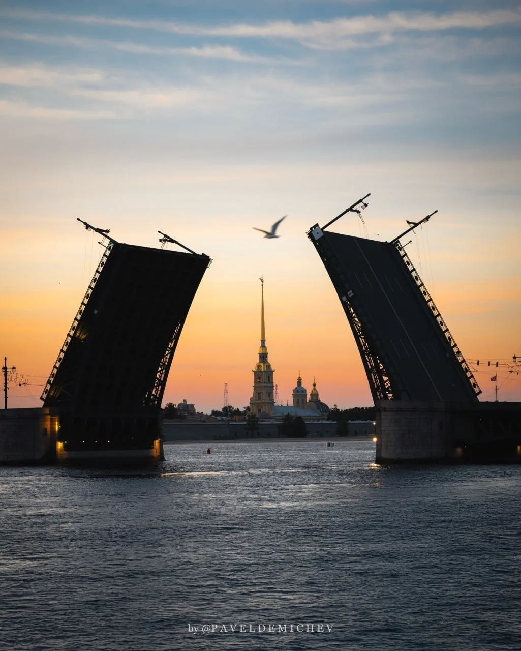 Дворцовый мост, расправивший плечи над Невой, и шпиль Петропавловской крепости, уходящи...